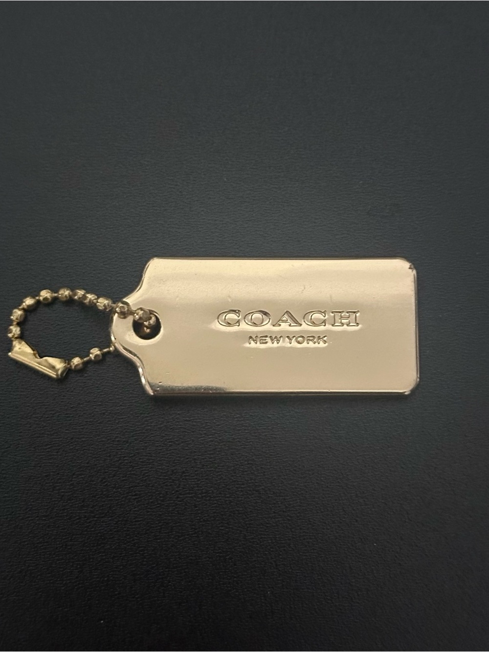 Coach gold metal hang tag